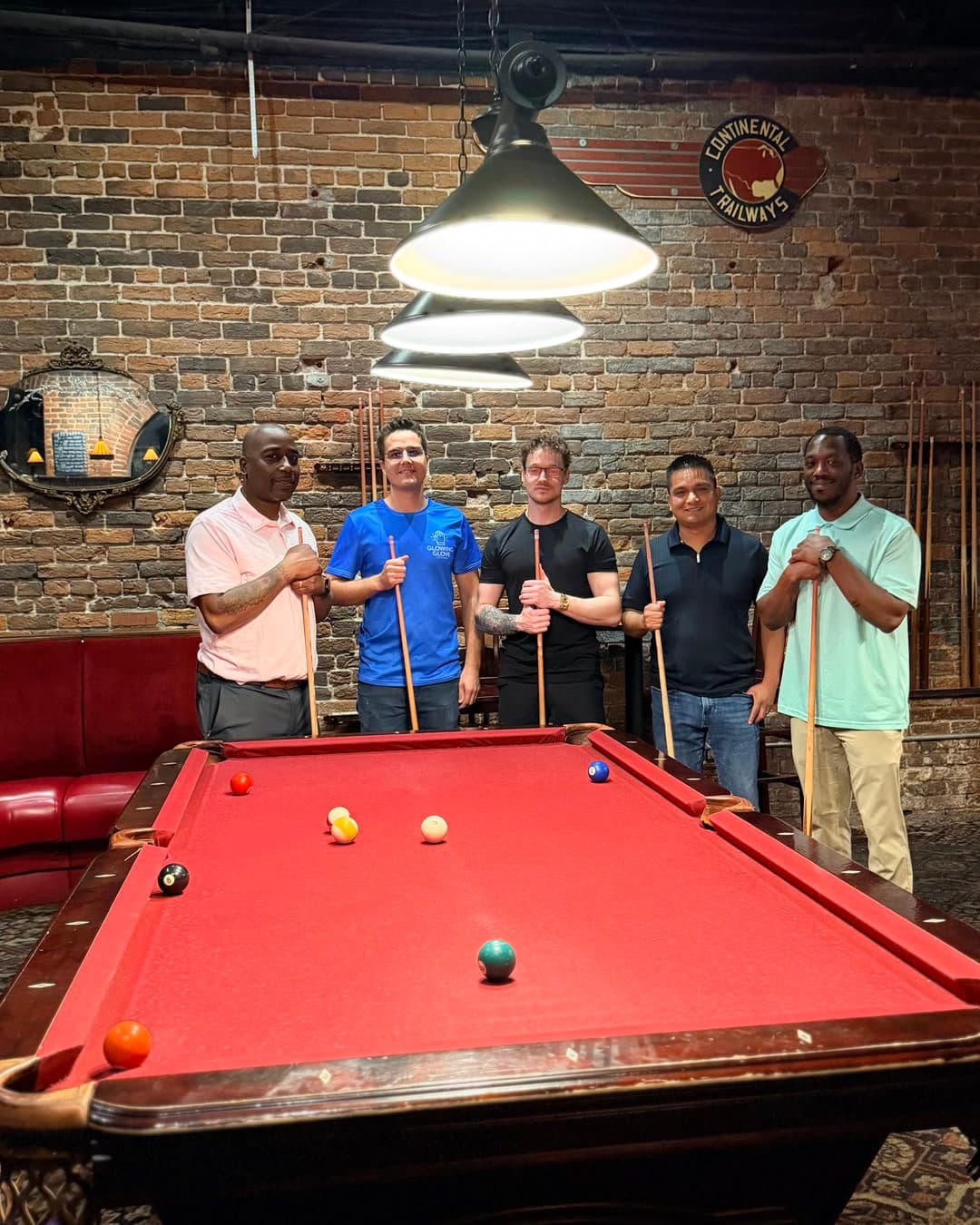 Five Builders Night guests gathered behind a pool table